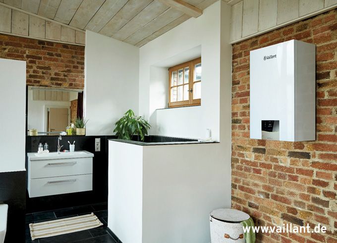 Badezimmer mit einer Ziegelwand und einem weißen Waschbecken.